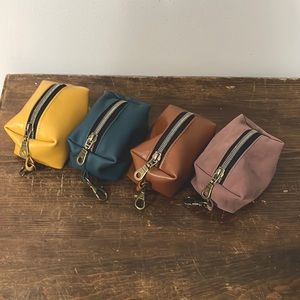 Handmade leather box pouches with antique brass hardware.